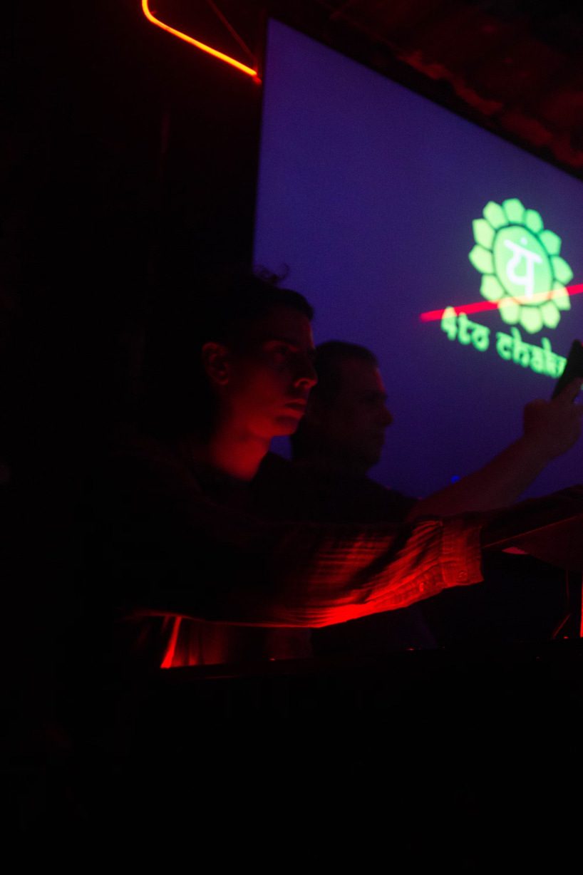 Lionel operando en cabina bajo luz roja y violeta, con una proyección de fondo.