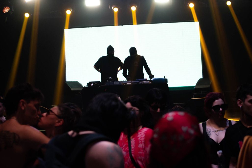 Siluetas en el escenario recortadas por haces amarillos de followspot.